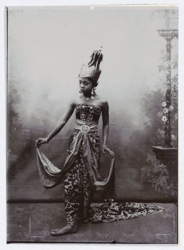 Studio Portrait of a Young Woman in a Batik Sarong and Embroidered Upper Garment, Wearing a Crown-like Headpiece