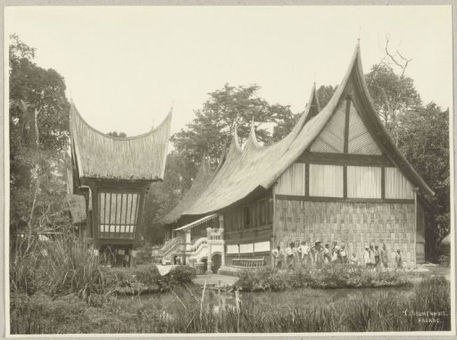 Group of men and children in front of a Minangkabau house