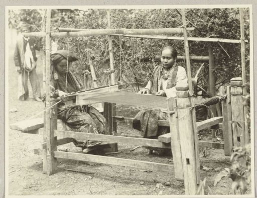 Two kain weavers at a loom on Sumatra