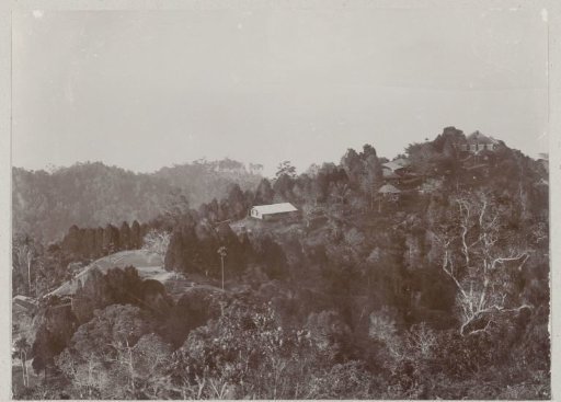 View of a landscape with several buildings and a bay in the background, probably on Sumatra