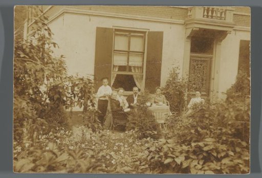 Portrait of an unknown family in the garden in front of a house