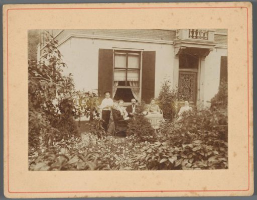Portrait of an unknown family in the garden in front of a house