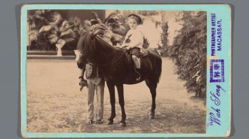 Portrait of an unknown child on a small horse with a servant
