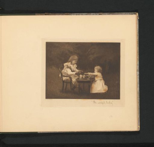 Two girls at a table in a garden with a toy tea set