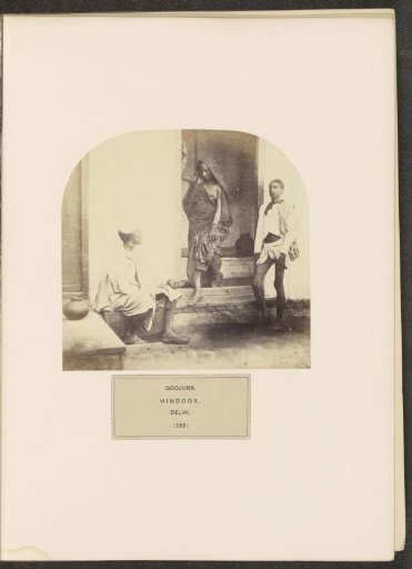 Two men and a woman from the Gujjar community at a door opening in Delhi, India
