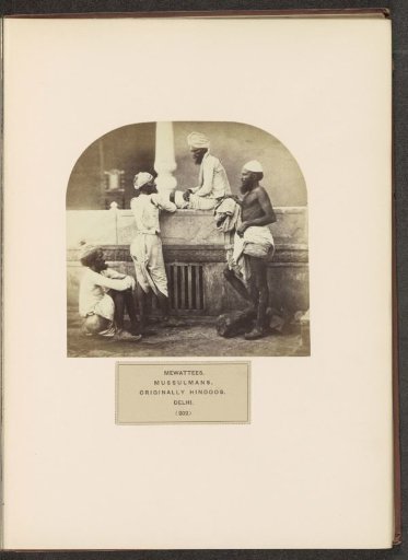 Four men from the Meo community around a wall in Delhi, India