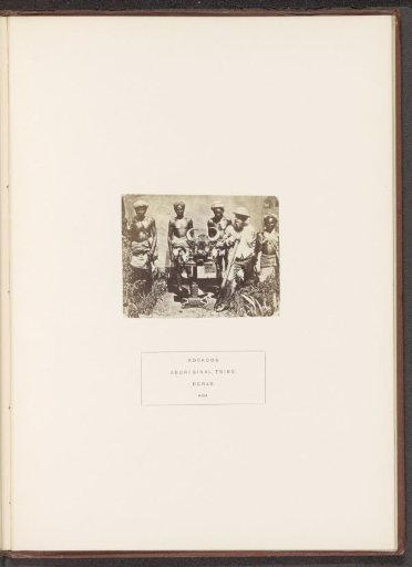 Group of four men from the Korku tribe and a British hunter around a table with a head of bison on it in the former Berar in central India
