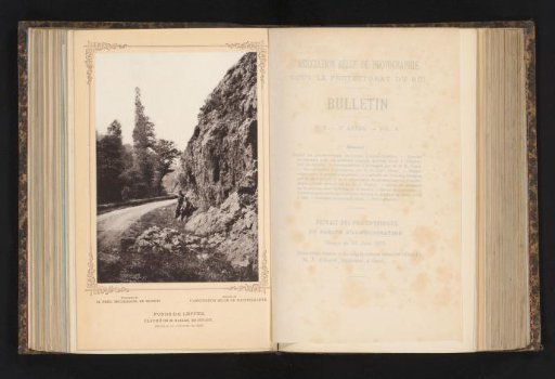 Two unknown men against a rock wall along a path