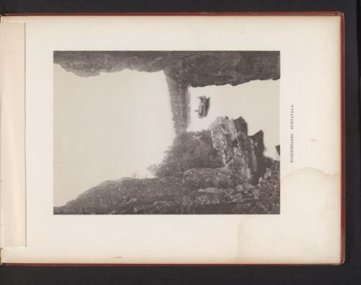 View of a steamboat on the water from a spot between two rocks