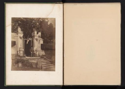 Seated unknown man with a rifle in front of the entrance to Fountains Hall