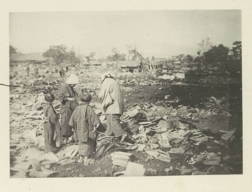 Two women with children standing amidst ruins in Japan after an earthquake