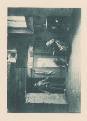 Man entering a room where a woman sits at a table