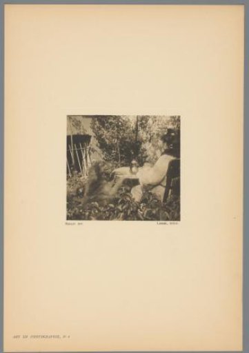 Woman and a dog sitting together at a table in a garden