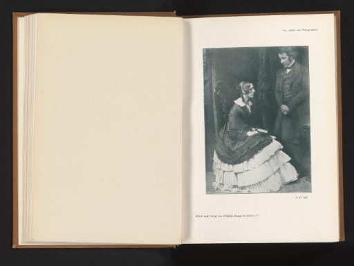 Woman sitting on a chair with a book in her hands, a man standing beside her