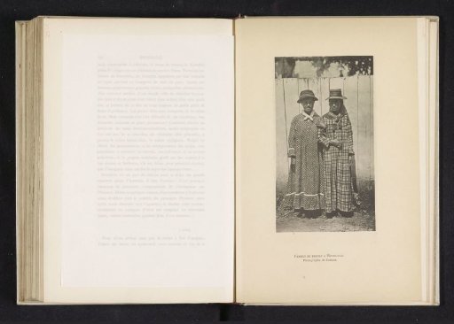 Two women in dresses before a fence in Honolulu