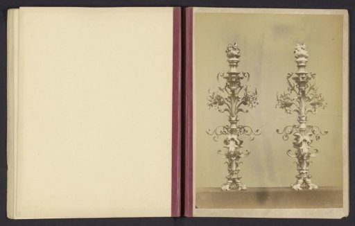 Two candlesticks decorated with leaf motifs and a flame