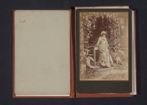 Portrait of an unknown woman in a garden before a table