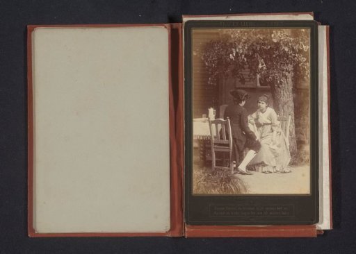 Portrait of an unknown woman and man, seated at a table in a garden