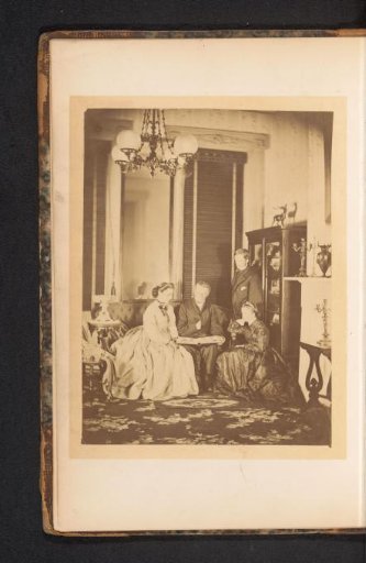 Two men and two women viewing an album in a living room