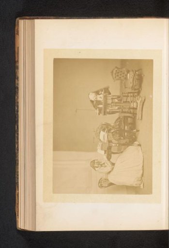 A boy playing at a table, while a girl reads at another table