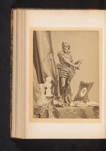 Bronze statue, picture frame, pipe and other items on a table