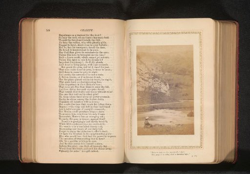 Mountain landscape with a body of water and a woman on the shore