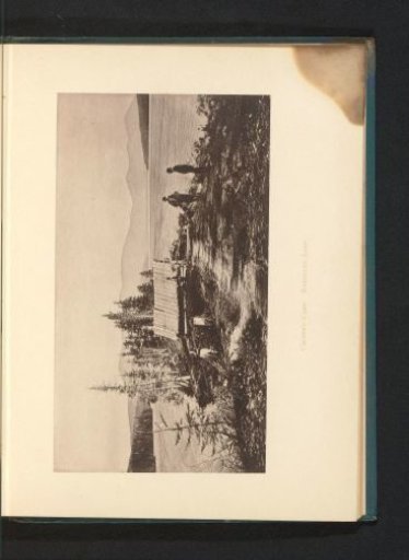 Three men at a hut, with Rangeley Lake in the background