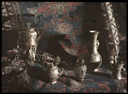 Still life of earthenware, copper and tin vases, goblet and pots on a carpet
