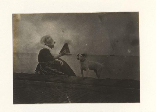 Woman in traditional dress with a dog by the water