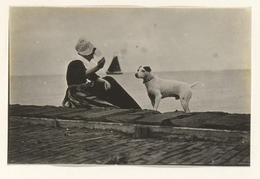 Woman in traditional dress with a dog by the water