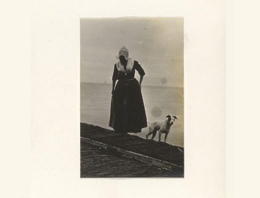 Woman in traditional dress with a dog by the water