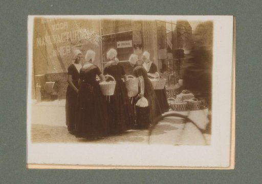 Women in traditional dress with baskets standing in the street