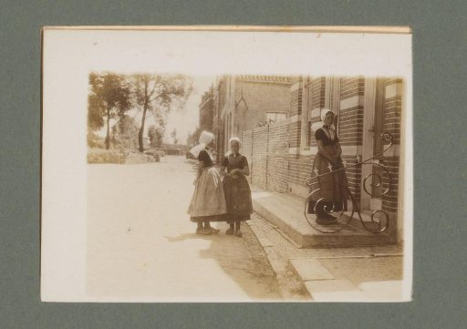 Three girls in costume standing in front of a house