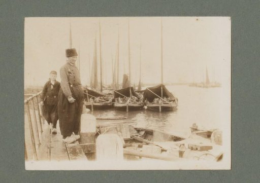 Man and boy in traditional dress, on a pier in a harbor