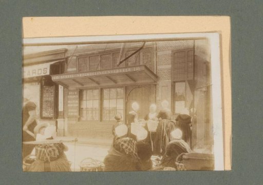 Women in Traditional Dress with Baskets, Standing Before the Tourist Office