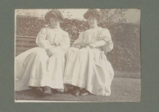 Portrait of two women in light dresses, seated in a garden