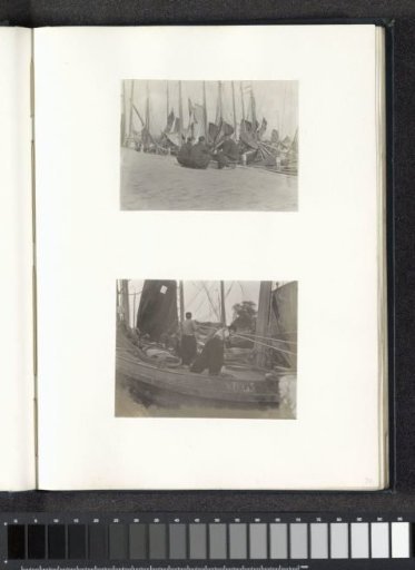 Two men in Volendam costume standing in a sailing ship