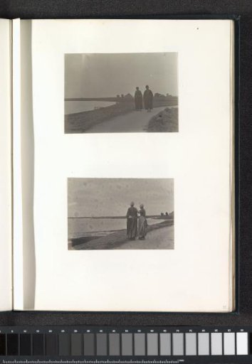 Two men in Volendam costume walking on a dike