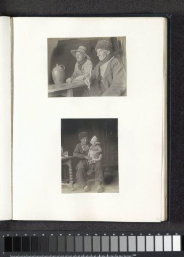 Portrait of two men in Volendam costume sitting at a table