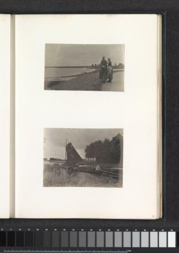 Two women in Volendam costume standing on a dike