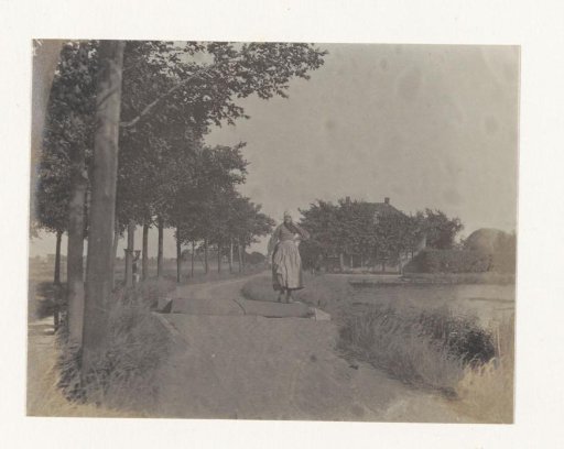 Woman in costume on a country road, probably in the vicinity of Volendam