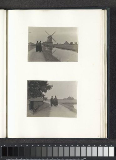 Two men in Volendam costume walking on a dike