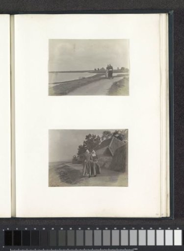 Two women in Volendam costume walking on a dike