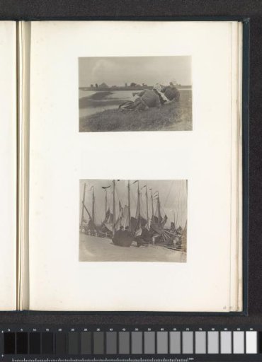 Two women in Volendam costumes lying on a dike