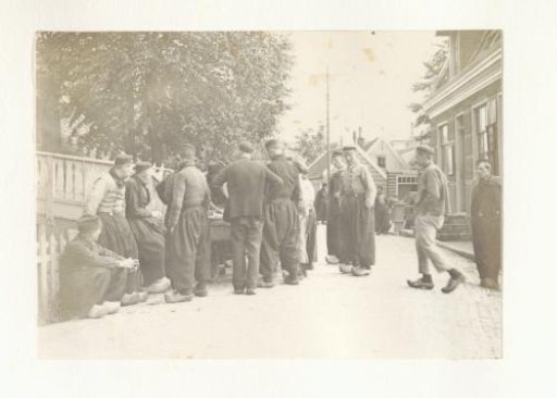 Men in Volendam costume around a cart on the street