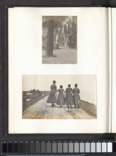 Four girls in Volendam costume on a dike by the water