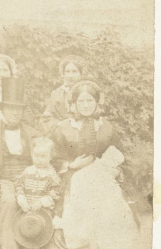 Group portrait of an unknown man, three women and two children