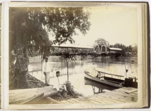 Paul Sandel in his steamboat with the Sandel Bridge in the background and two Chinese servants in the foreground, Tandjong Poera, Langkat Sumatra