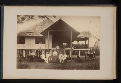 Group of Europeans in front of the assistants' house at the Bindjai Plantation, Sumatra, with beer on the table