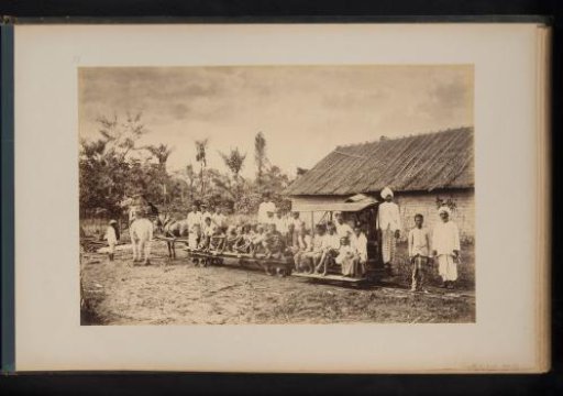 Group of people on rail carts pulled by horses in Lau-Boentoe, Sumatra